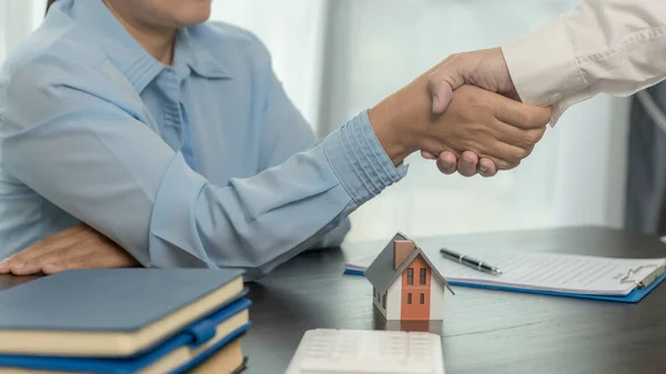 Estate agent shaking hands with client after contract signature and done business deal for transfer right of property. Man broker realtor real estate agent shake hands of happy clients homeowners