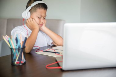 Young student distance learning virtual distance online class on video call virtual lesson, technology studying at home using laptop computer. Parent or tutor teaching child boy with remote education.