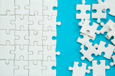 White part of jigsaw puzzle pieces on blue background. concepts of problem solving, business success, teamwork, Team playing jigsaw game incomplete, Texture photo with copy space for text