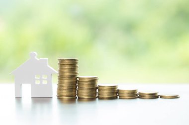 House and stack money coins with background to save for residential. Cash financial plan for loans or mortgages and investments with bank. Concept for house insurance business and real estate growth