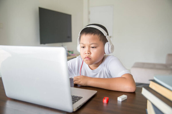 Young student distance learning virtual distance online class on video call virtual lesson, technology studying at home using laptop computer. Parent or tutor teaching child boy with remote education.
