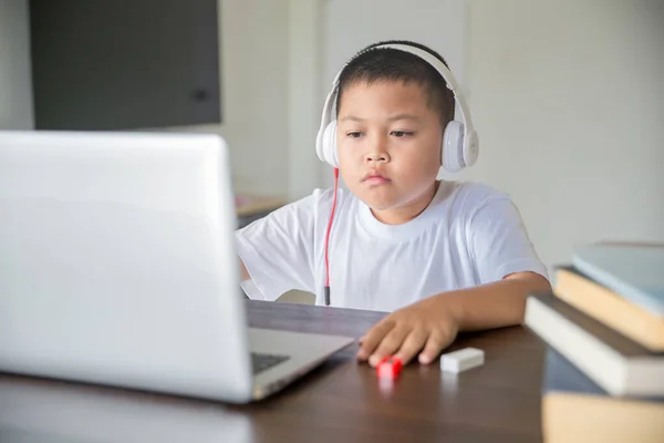 Young student distance learning virtual distance online class on video call virtual lesson, technology studying at home using laptop computer. Parent or tutor teaching child boy with remote education.