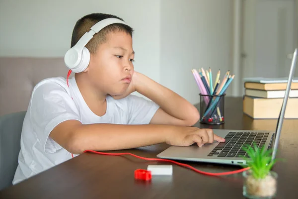 Young student distance learning virtual distance online class on video call virtual lesson, technology studying at home using laptop computer. Parent or tutor teaching child boy with remote education.