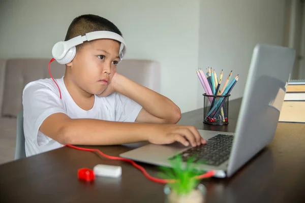 Young student distance learning virtual distance online class on video call virtual lesson, technology studying at home using laptop computer. Parent or tutor teaching child boy with remote education.