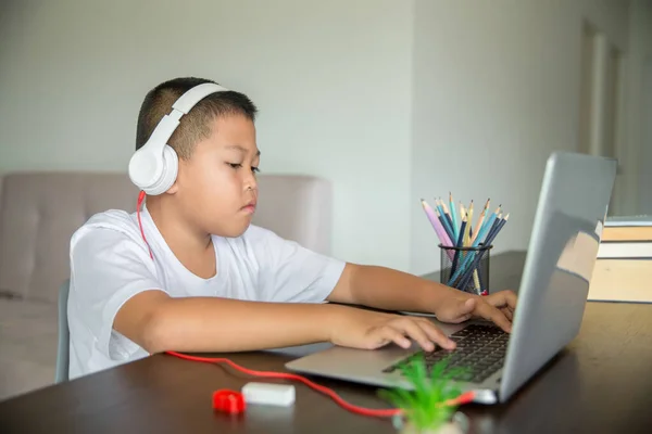 Young student distance learning virtual distance online class on video call virtual lesson, technology studying at home using laptop computer. Parent or tutor teaching child boy with remote education.