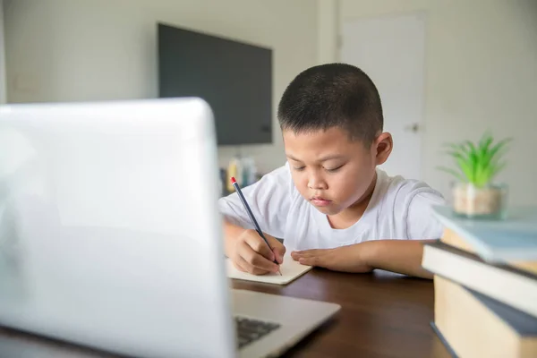 Young student distance learning virtual distance online class on video call virtual lesson, technology studying at home using laptop computer. Parent or tutor teaching child boy with remote education.