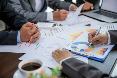 Group professional business people person working together to analyze in office, work together to discuss company financial statistics report, brainstorm ideas, and graph datum documents on the table.
