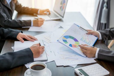 Group professional business people person working together to analyze in office, work together to discuss company financial statistics report, brainstorm ideas, and graph datum documents on the table.