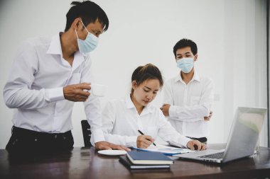 Group business people have a meeting businessman wearing mask and businesswoman not wearing mask working in a office