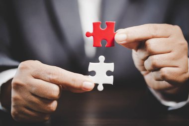 Business woman person hand holding puzzle piece idea for strategy and solution. Closeup part of two white jigsaw connect together. Concept of join cooperation success teamwork-problem corporate team