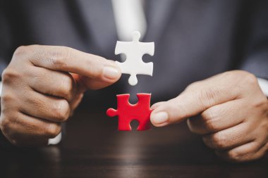 Business woman person hand holding puzzle piece idea for strategy and solution. Closeup part of two white jigsaw connect together. Concept of join cooperation success teamwork-problem corporate team