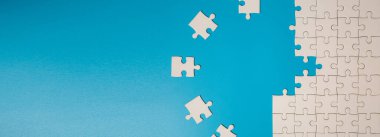 White part of jigsaw puzzle pieces on blue background. concepts of problem solving, business success, teamwork, Team playing jigsaw game incomplete, Texture photo with copy space for text
