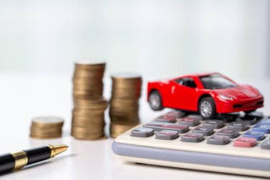 Arka planda bozuk para yığını olan oyuncak araba. Ulaşım finansmanını yönetmeyi planlıyorum. Araba sigortası işi kavramı, tasarruf satın alma - yeni araba için vergi ve kredi ile satış.