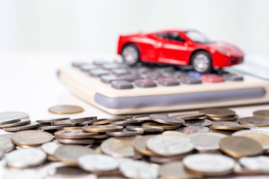 Arka planda bozuk para yığını olan oyuncak araba. Ulaşım finansmanını yönetmeyi planlıyorum. Araba sigortası işi kavramı, tasarruf satın alma - yeni araba için vergi ve kredi ile satış.
