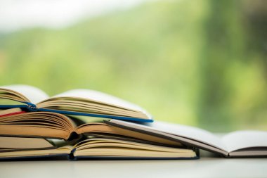 Object education green nature background with stack of ancient books or old bible, open paper book on wooden table with copy space. concept of back to school, research study