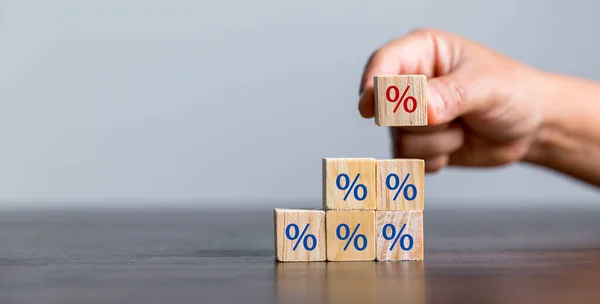 Closeup wood cubes with percentage symbol, Interest rate and dividend concept, wooden block with percentage symbol and up arrow, return on stocks and mutual funds, long term investment for retirement.