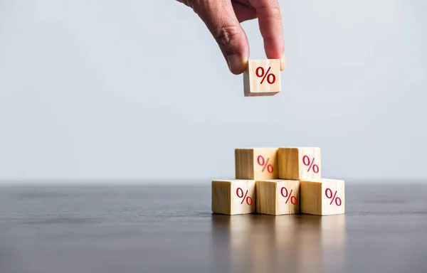 Closeup wood cubes with percentage symbol, Interest rate and dividend concept, wooden block with percentage symbol and up arrow, return on stocks and mutual funds, long term investment for retirement.