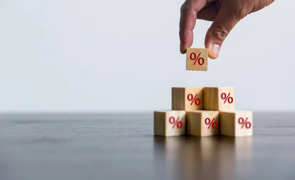 Closeup wood cubes with percentage symbol, Interest rate and dividend concept, wooden block with percentage symbol and up arrow, return on stocks and mutual funds, long term investment for retirement.