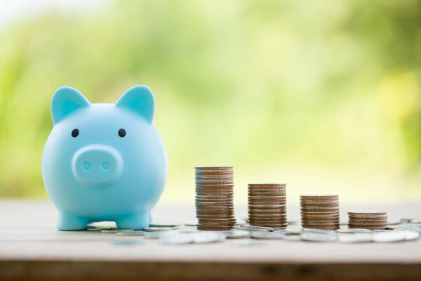 Savings for business investments concept. Money coin stacking on wood desk in green background. management cash, insurance asset and wealth, tax accounting budget, growth loan financial, economic.