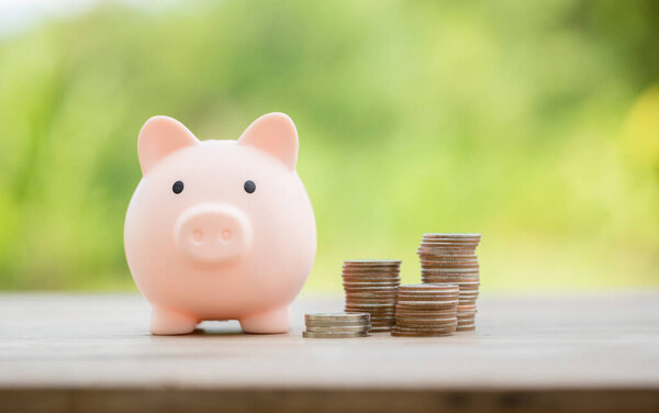 Savings for business investments concept. Money coin stacking on wood desk in green background. management cash, insurance asset and wealth, tax accounting budget, growth loan financial, economic.