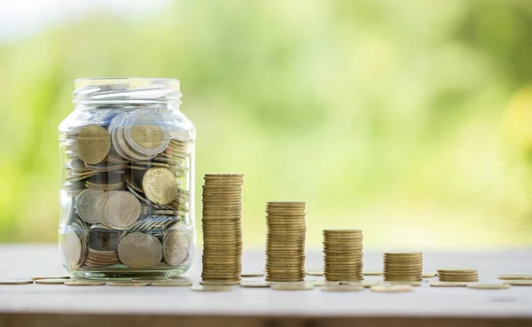 Savings for business investments concept. Money coin stacking on wood desk in green background. management cash, insurance asset and wealth, tax accounting budget, growth loan financial, economic.