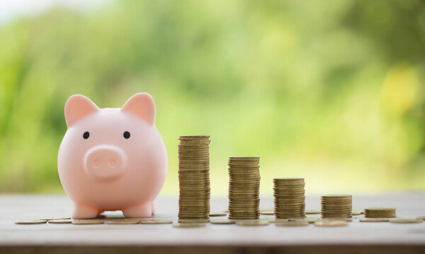 Savings for business investments concept. Money coin stacking on wood desk in green background. management cash, insurance asset and wealth, tax accounting budget, growth loan financial, economic.