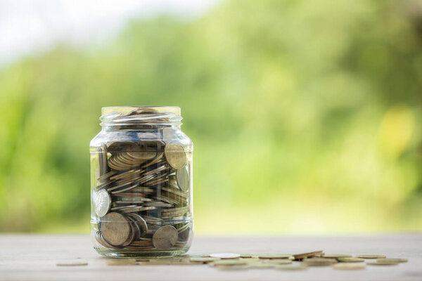 Savings for business investments concept. Money coin stacking on wood desk in green background. management cash, insurance asset and wealth, tax accounting budget, growth loan financial, economic.