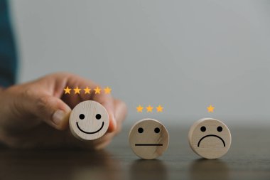 Memnuniyet araştırması konsepti. Müşteri hizmetleri en iyi iş derecelendirme deneyimi. İş kolu tahta blok çemberinde gülen bir yüz seçiyor. 5 Yıldız Memnuniyeti. İnsanlar kendilerini harika hissediyorlar..