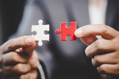Business woman person hand holding puzzle piece idea for strategy and solution. Closeup part of two white jigsaw connect together. Concept of join cooperation success teamwork-problem corporate team