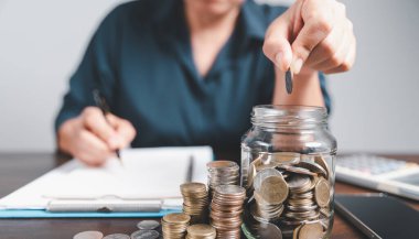 Yatırım bankacılığı finans kavramını kurtarıyorum. Masada kumbarası olan bir yığın bozuk para. Kredi ve yatırım iş fikrinin büyümesi. Varlık Yönetimi, Fonlar, Sorumluluklar, Mevduatlar, Gelir, Başarılı.