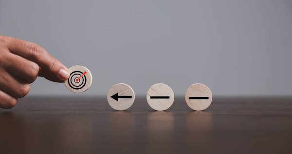 Target or goal with strategy plan-success business revenue concept. Symbols of arrows-diagrams businesses are present on wood cube. objective management, achievement startup, growth marketing idea.