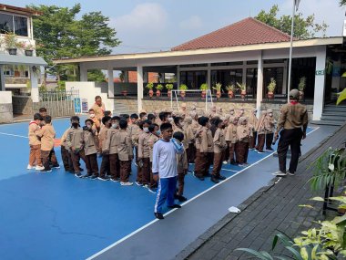 Spor üniformalı bir çocuk 20 Temmuz 2020 'de Depok Distric Batı Java Eyaleti Endonezya' sında İlköğretim Okulu İzcisi arasında bir sıra oluşturmaya çalışıyor.