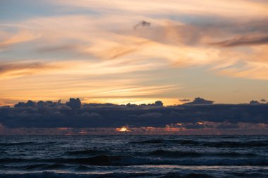 View of colourful sunset of the Baltic sea. Picturesque seascape on a sunset. Horizon over the water. Spectacular sky in sunset.