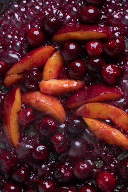 Close-up of delicious, caramelized cherries and nectarines in pan. Appetizing pan-fried fruits for dessert. Excellent image for homemade dessert banners and advertisements.