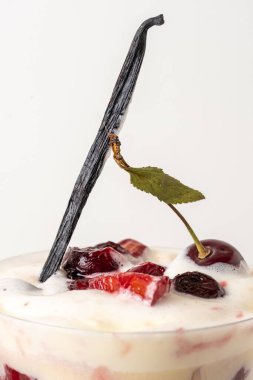 Close up of delicious milk dessert with fresh strawberries and cherries served in glass. White background. Greeting card. Excellent image for dessert banners and advertisement.  Place for your text.