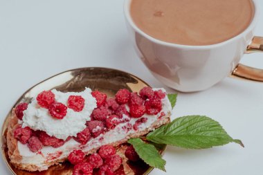 Taze ahududu ve arka planda bulanık aromalı kahve ile nefis bir parça kek. Bulanık beyaz arka plan. Güzel kavram. Tatlı afişleri ve reklamları için mükemmel bir görüntü..