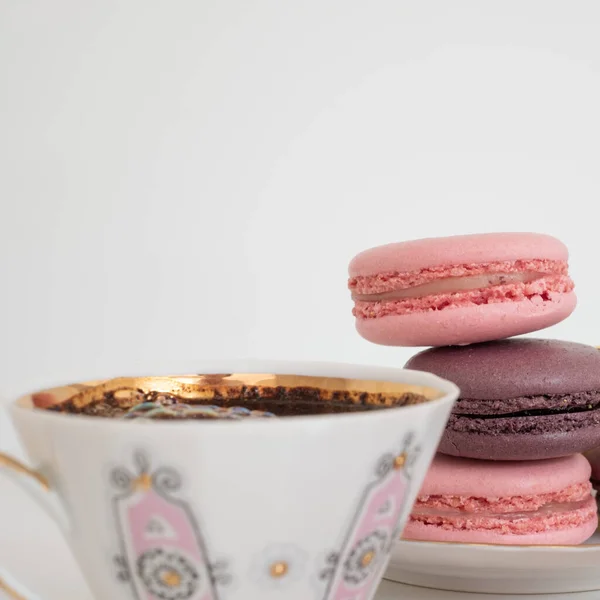 Крупный План Аппетитный Розовый Фиолетовый Макарон Чашку Кофе Белом Фоне — стоковое фото