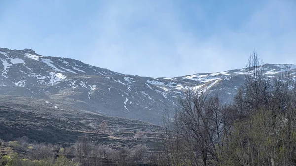 Açık Mavi Gökyüzü Ile Kısmen Kaplı Kayalık Dağlara Bakın Arka — Stok fotoğraf
