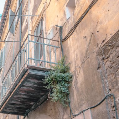 Arka planda antik bir bina bulunan metal tasarım tırabzan ile balkon manzarası