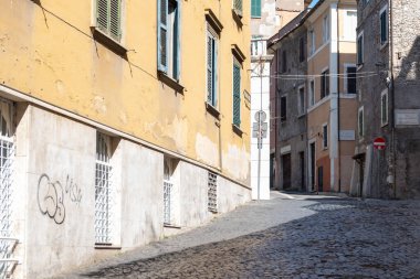 Eski şehir parke taşı caddesini daraltmak ve bu sokağın kenarındaki antik binaları bir yaz günü arka planda gökyüzü ile.