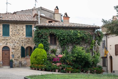 Antik aydınlık taş bina manzaralı. Bina duvarının yanında bir sürü çiçek var ve antik taş duvarda korunuyor..