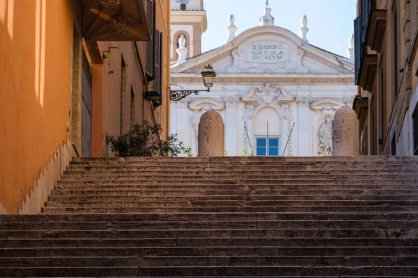 Arka planda mavi gökyüzü ve taş duvarlar ve ön planda büyük taş merdivenlerle Roma Katolik Kilisesi için etkileyici bir manzara.