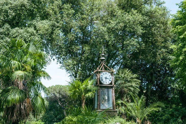 Spectacular view to the magical Pincio water clock in Rome with blue sky and trees in park in background.