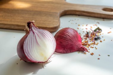 Güneşli bir yaz gününde, beyaz bir masada, kırmızı bir onio 'nun iki yarısı