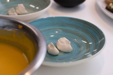 Yeşil ve sebzeli mavi tabaklar ve parlak sarı domates çorbası. Sağlıklı yemek reklamı, mutfak geçmişi..