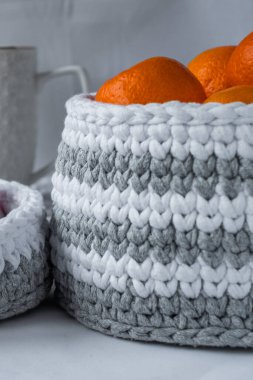 Çizgili beyaz, gri bardak altlığı, beyaz kış modunda kahve fincanı ve sepet şekerli, çizgili örgü sepetli, doğa dostu sürdürülebilir el işi, şirin iç malzemeler. Metnin için boşluk