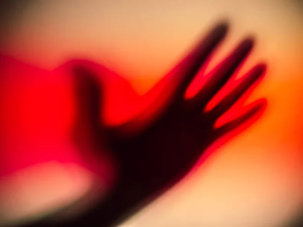 A bloody shadow of a silhouetted hand.