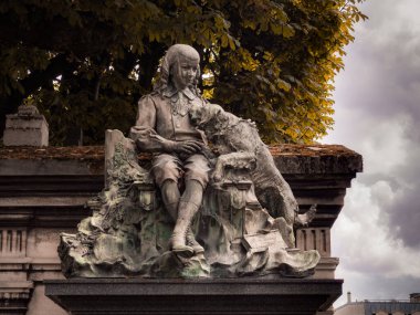 Sculptures of a girl and a dog in the famous Pere Lachaise cemetery. The cemetery is a tourist destination since many famous people sleep there. June 6, 2022.