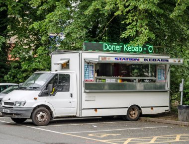 Basingstoke, İngiltere - 3 Temmuz 2021: Güneşli bir yaz akşamında Basingstoke, Hampshire 'daki tren istasyonunun yanına park edilmiş İstasyon Kebabları yemek kamyonunun görüntüsü.