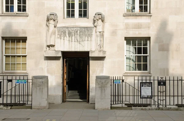Londra, İngiltere - 21 Mart 2022: Kraliyet Dramatik Sanatlar Akademisi 'nin ana girişi - RADA - Gower Caddesi, Camden, Central London. Bir heykel, trajedinin maskesini tutan memnun bir kadını ve zavallı bir adamı gösteriyor.